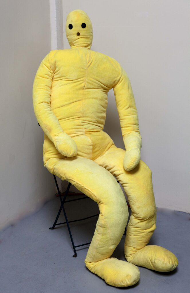 fuzzy yellow stuffed man doll is 6'7" with button eyes by Diana Kohne